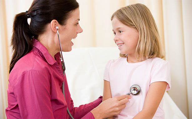 Doctor listening to young girl's heartbeat