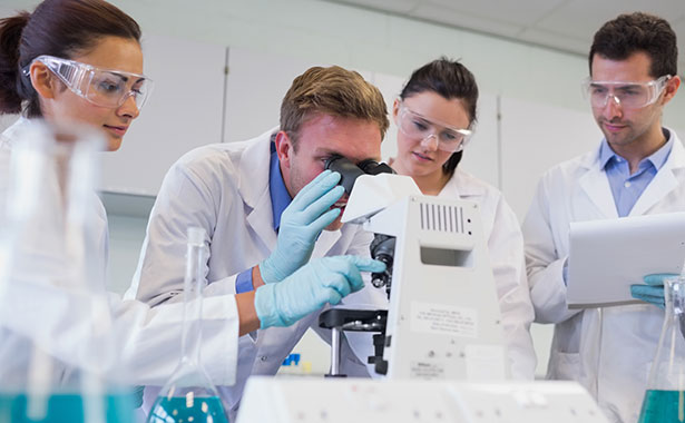 Group of students looking through a microscope